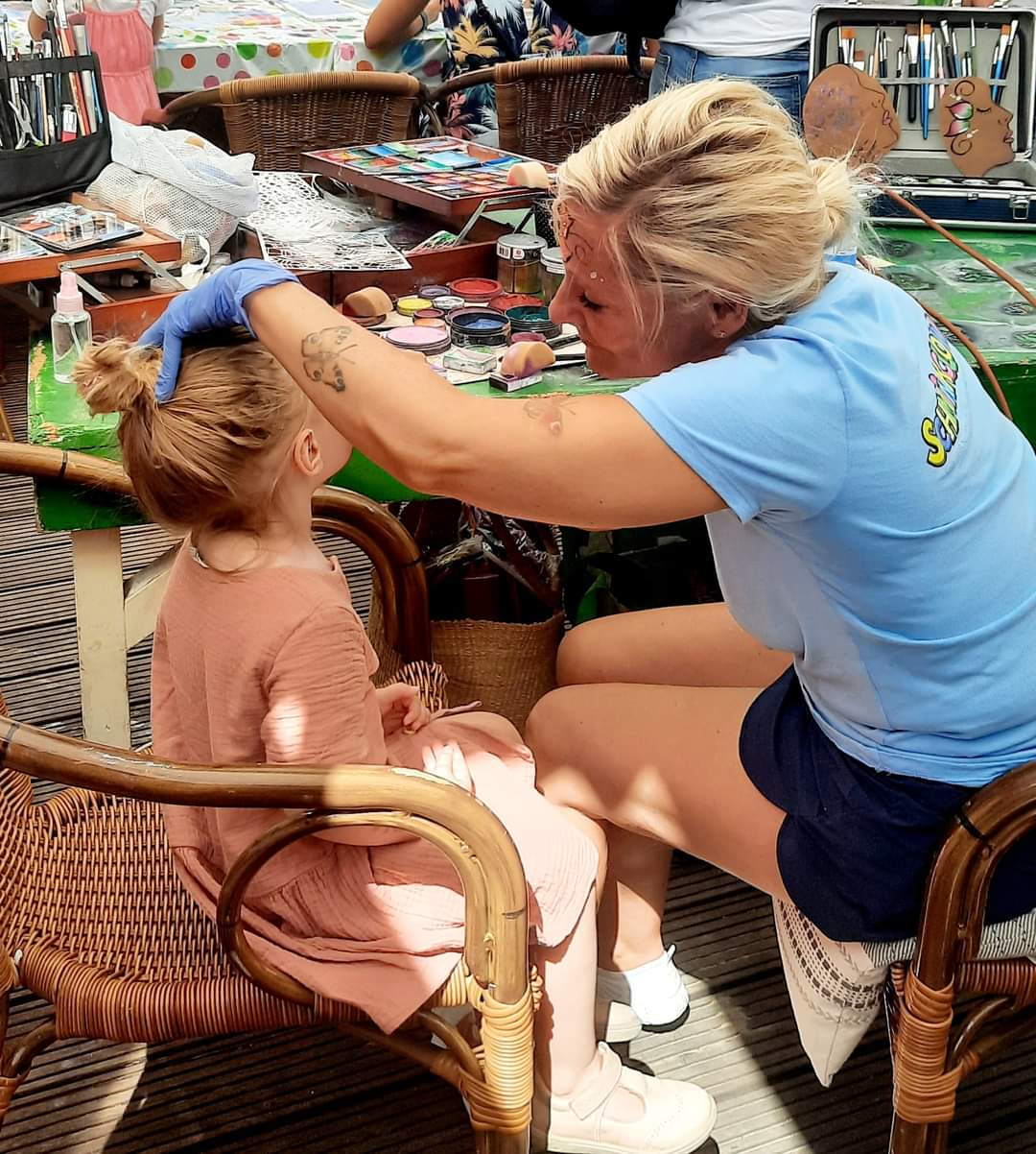 Manuela beim Kinderschminken: Pinsel, Farben und ein Kind, das sich gerade verwandelt